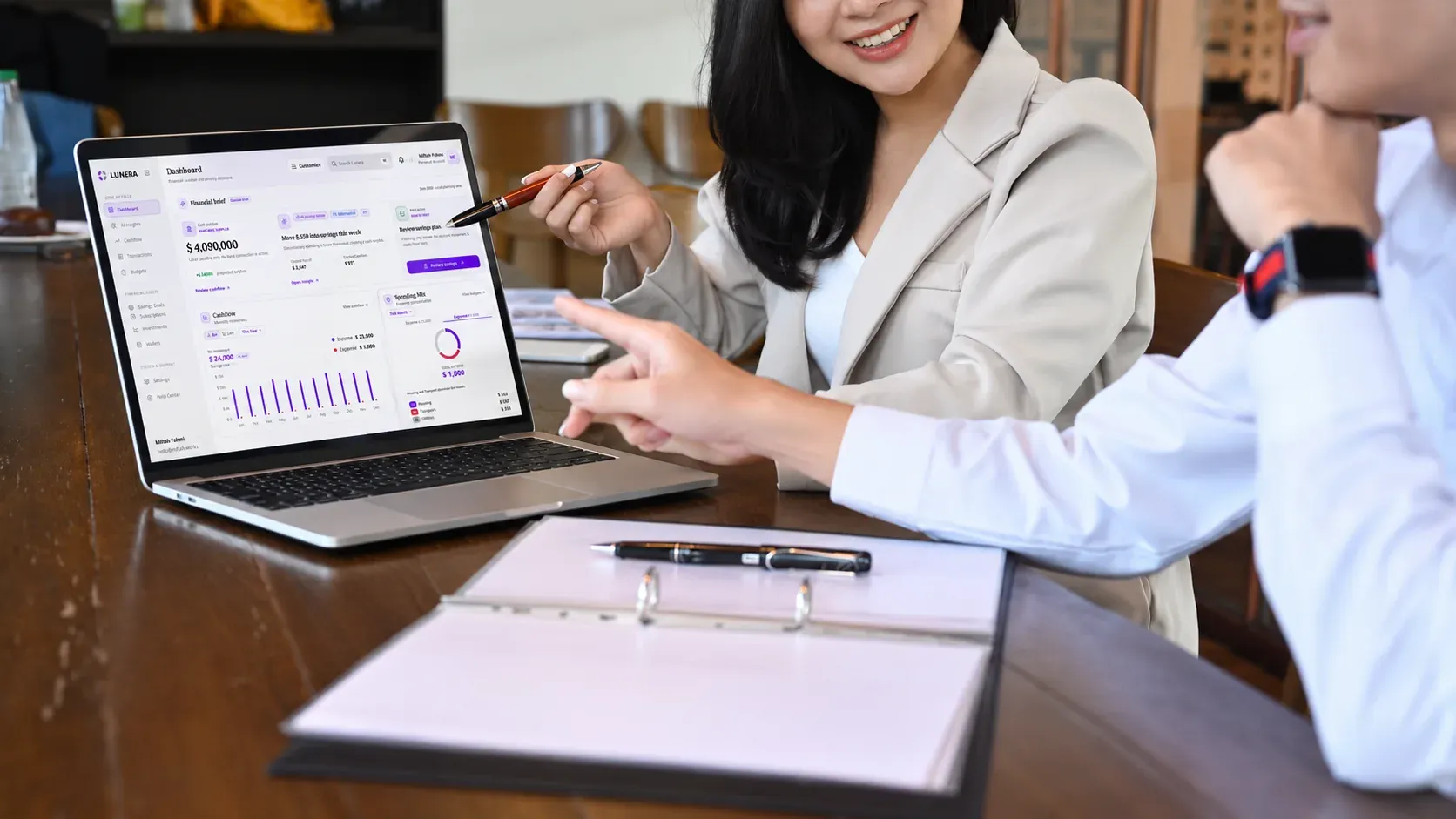 Two people reviewing Lunera’s financial dashboard together on a laptop